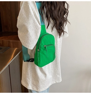 Detail of vibrant green nylon crossbody bag showing the adjustable blue fabric strap
