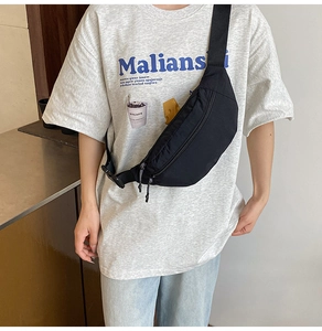 Detail of black waterproof nylon waist bag with adjustable strap worn as a crossbody pack