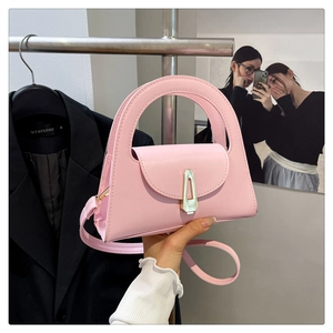 Detailed view of a pink leather semi-circle bag featuring a gold metal shield lock