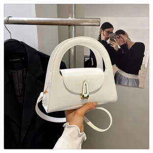 Detail of white leather handbag showing semi-circular handle and gold metal buckle