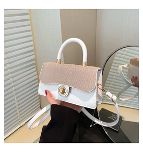 Detail view of white leather crossbody bag with brown woven texture flap and gold lock