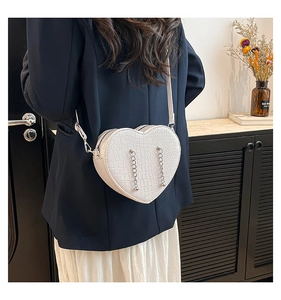 White heart-shaped crossbody bag with crocodile texture and silver chain tassels