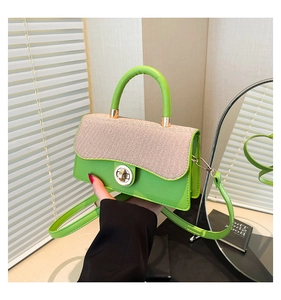 Detail of lime green and beige woven crossbody bag featuring a wavy flap and metal lock
