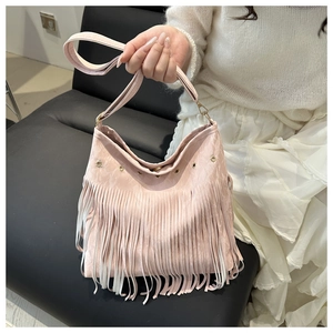Detail view of the pink fringe shoulder bag with long tassels and silver metal eyelets