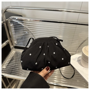 Detail of black cloud bag with white floral embroidery and drawstring design