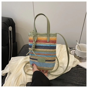 Detail of colorful woven shoulder bag with FASHION leather tag on white fabric