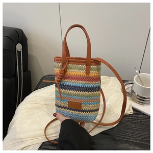 Close-up of multicolored woven mini bag with leather handles and Fashion patch detail