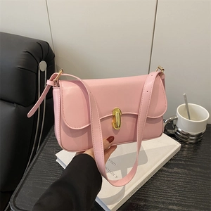 Pink leather baguette bag with gold metal buckle shown in a lifestyle scene