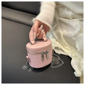 Detail of pink vanity bag showing leather and woven texture with silver chain strap