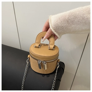 Detailed view of mini bucket bag with straw texture, yellow leather trim and dual zippers