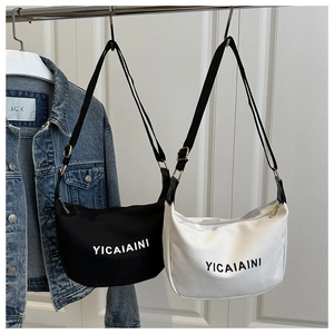 Detail of canvas crescent tote with adjustable strap and YICAIAINI letter print