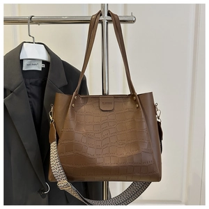 Detail of crocodile embossed leather tote bag with stylish braided shoulder strap