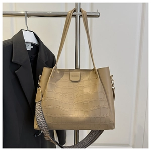 Detail of crocodile embossed tote bag with adjustable woven strap and metal hanger display