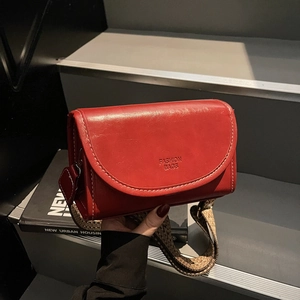 Red retro leather crossbody bag with contrast stitching and wide woven shoulder strap