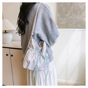 Floral bucket bag with drawstring and blue checkered bow detail on a fashion model