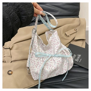 Detailed view of floral canvas tote with light blue checkered ribbon and soft bow