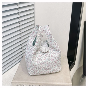 Close-up of floral tote bag featuring white lace trim and green checkered lining