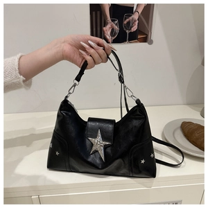 Detail of black faux leather shoulder bag with silver star rivets and metal buckle