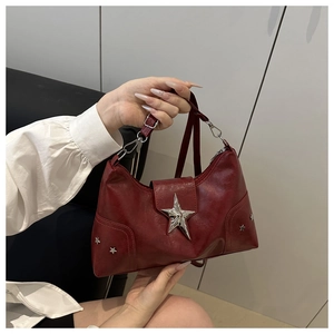Detail of burgundy leather shoulder bag showing silver star rivets and metal hook