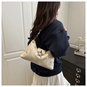 Detail of champagne gold Y2K shoulder bag with metallic star buckle and rivet accents