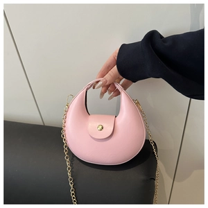 Detail van roze halve maan tas met gouden ketting en metalen ronde sluiting