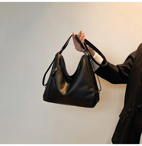 Side view of black faux leather hobo shoulder bag featuring decorative zipper detailing