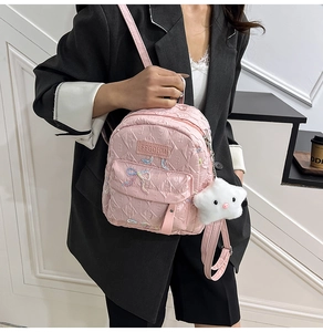 Pink mini backpack detail featuring embossed texture and a white star plush pendant