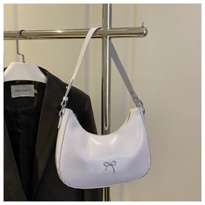 Detail of lavender patent leather crescent bag with a metallic silver bow accent