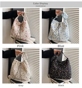 Detail view of four seersucker floral drawstring handbags in pink, blue, gray, and black