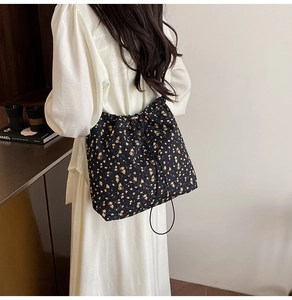 Detailed view of floral pattern nylon drawstring bucket bag with textured fabric