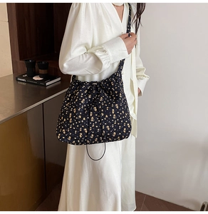 Detail of floral nylon bucket bag with drawstring closure and 3D textured fabric