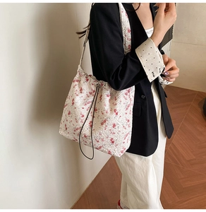 Close-up of floral nylon tote bag featuring drawstring detail and textured fabric