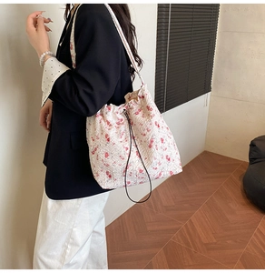Detail of floral nylon shoulder bag with pleated texture and drawstring closure