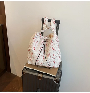 Close-up of floral nylon bucket bag with red flower pattern and pleated fabric texture