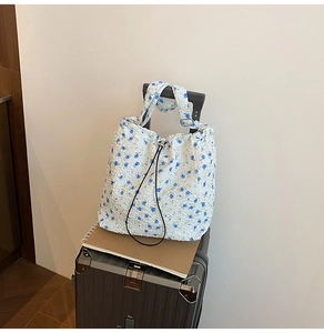 Floral nylon cradle bag with drawstring placed on a suitcase for travel convenience