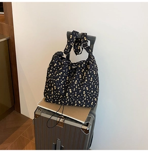 Close-up of floral nylon tote bag with drawstring and adjustable metal buckle