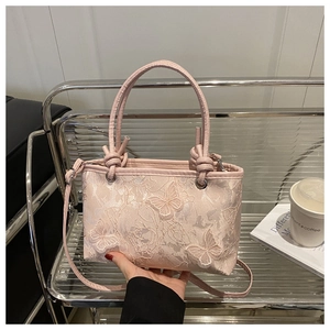 Detail of pink lace handbag with 3D butterfly embroidery and adjustable shoulder strap