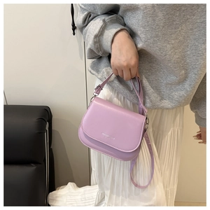 Detail of lilac saddle bag with Fashion Trend text and adjustable shoulder strap