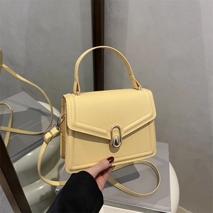 Minimalist light yellow rectangle crossbody bag with oval metal clasp and top handle