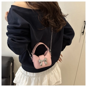 Pink mini crossbody bag with silver bow accent and chain strap shown from behind