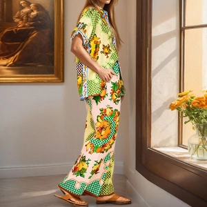 Detail of vibrant tropical fruit print and fluid fabric texture on holiday shirt and trousers