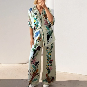Close-up of printed silk shirt and wide-leg pants set with vibrant exotic floral patterns