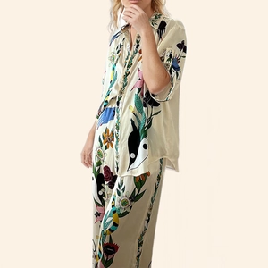 Detail of satin two-piece set featuring colorful floral prints and wide-leg pants