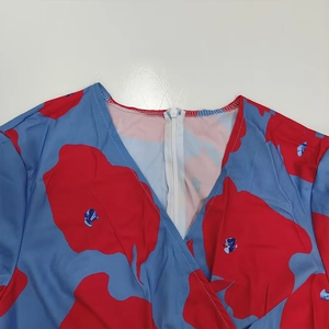 Close-up view of V-neck and abstract floral print on elegant blue and red dress