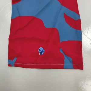 Detailed macro view showing the hem stitching and fabric texture of a red blue floral dress