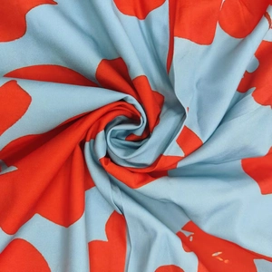 High-quality close-up of elegant orange and blue floral print dress fabric with smooth texture