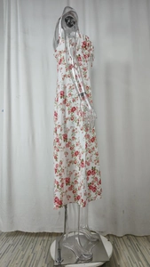 Detail view of white floral dress showing side drawstring ruching and red rose pattern