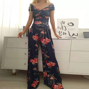 Dettaglio di tuta blu navy con stampa floreale di rose rosse e scollatura a V in vita