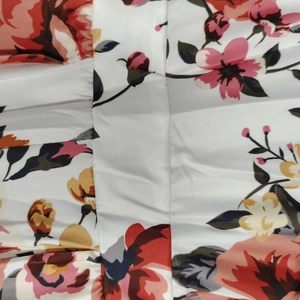 Dettaglio macro della stampa floreale su tessuto bianco con cuciture per tuta donna
