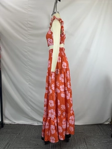 Detail of vibrant orange two-piece set featuring tropical floral print and tiered skirt